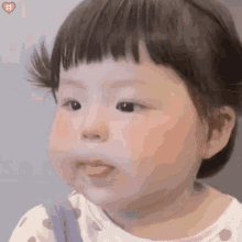 a little girl with her tongue out is making a funny face .