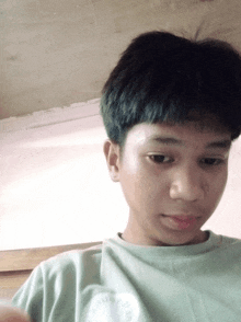 a young boy wearing a green shirt with the word converse on the front