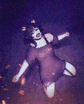 a girl in a purple dress is laying on the ground with her arms outstretched ..