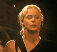 a close up of a woman 's face with her eyes closed and a ponytail .