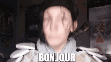 a man in a hat is holding a bunch of packets and says bonjour