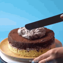 a person is spreading frosting on a chocolate cake with the word mr. cakes below it
