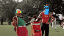 a man wearing a shirt that says brewing is standing next to a red golf bag