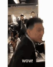 a man is taking a picture of himself in a mirror with the words wow written on it .