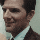 a man wearing a suit and tie is smiling