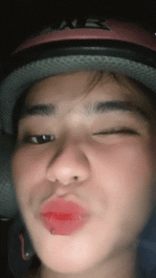 a close up of a person 's face wearing a helmet and making a silly face