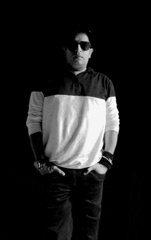 a black and white photo of a man wearing sunglasses and a black shirt