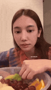 a woman is eating a bowl of fruit with the words " dont defy me " on the bottom right