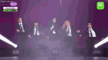a group of women in suits and ties are dancing on stage .