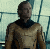 a man in a gold and black superhero suit is smiling