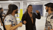 a group of men are standing in a room and one of them is holding a can of coke