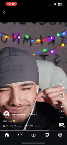 a phone screen shows a video of a man wearing headphones