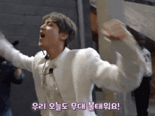 a man in a white suit is screaming with his arms outstretched