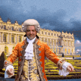 a man wearing a wig and a coat with a large building in the background