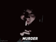 a close up of a person holding a gun in a dark room with the word murder written on the bottom .