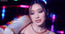 a close up of a woman wearing a choker and blue eyeshadow .