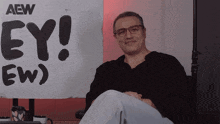 a man sitting in front of a sign that says ey
