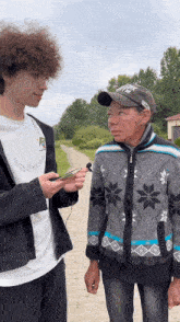 a man wearing a hat with the letter r on it is talking to a young man