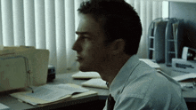 a man sits at a desk in front of a window with a folder on it that says ' attorney ' on it