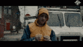 a man wearing headphones is standing in front of a truck with a stop sign in the background