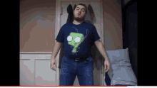 a man with a beard wearing a shirt with a green cartoon character on it
