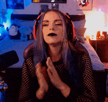 a woman wearing headphones is clapping her hands