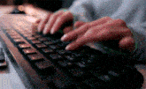 a person is typing on a black keyboard with the shift key visible