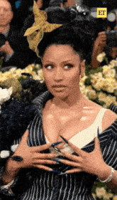 a woman with long nails and a flower in her hair is being photographed by a cameraman with the letters et on the bottom right