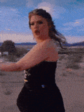 a woman in a black dress with a skull and crossbones on the back