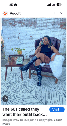 a woman is sitting in a chair talking on a telephone