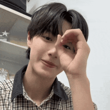 a young man making a heart shape with his hand