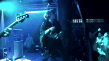 a man playing a guitar with the number 2222 on the back
