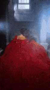 a woman in a red dress is laying down on a set of stairs