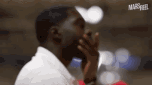 a man in a white shirt is covering his mouth with his hand and the word mars reel is visible in the corner
