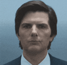 a close up of a man 's face in a suit and tie