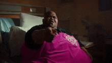 a man wearing a pink shirt that says purple stuff on it
