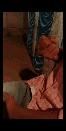 a man in a pink shirt is making a middle finger gesture