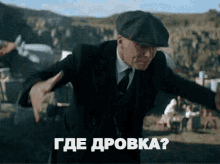a man in a suit and hat is dancing in front of a sign that says " где дровка "