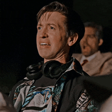 a man wearing jbl headphones and a shirt that says hawaii on it