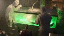 a group of people in white suits are standing around a table with green lights