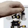 a hand is holding a stuffed animal in front of a stuffed animal .