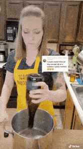a woman in a kitchen wearing a yellow apron that says team masters