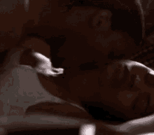 a man is kissing a woman on the forehead while laying on a bed .