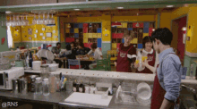a group of people standing in a restaurant with a watermark that says rns