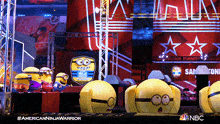 a group of minions are standing in front of a sign that says nbc