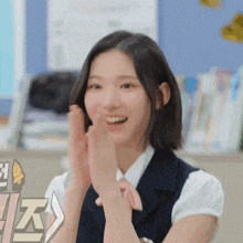 a woman in a school uniform is clapping her hands in a classroom