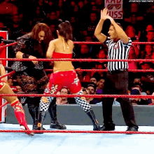 a referee is giving a high five to a wrestler in the ring