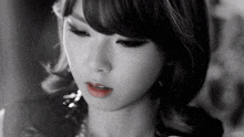 a black and white photo of a woman 's face with red lipstick on her lips .