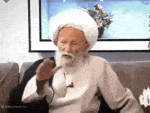 an elderly man with a beard wearing a white turban