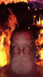 a close up of a person 's face with flames behind them